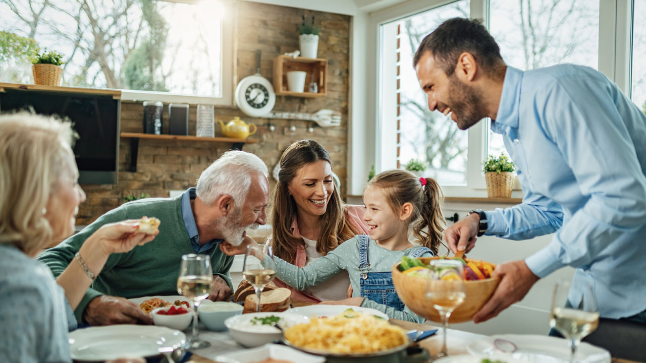 Multi-generational family enjoying a meal together, representing life's work protection